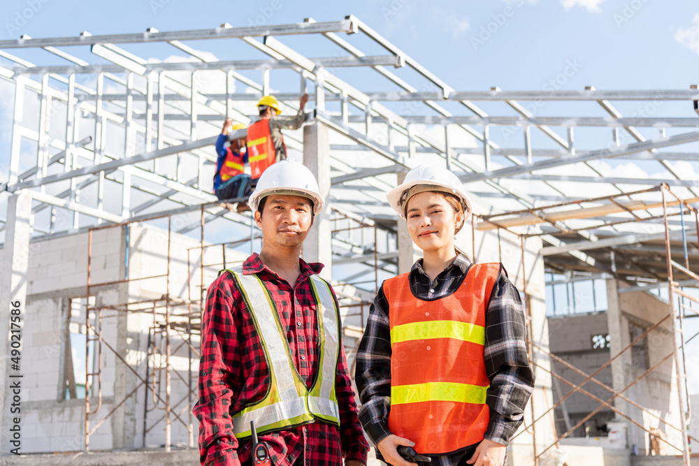 Architect and client standing at home building construction site. Portrait Asian engineer foreman worker man and woman in hardhat posing on building, Concept for team work Architect and client standing at home building construction site. Portrait Asian engineer foreman worker man and woman in hardhat posing on building, Concept for team work