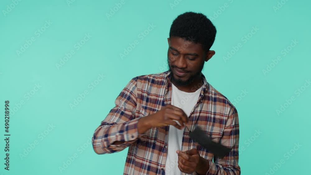 African american smiling man happily removing, taking off medical mask and throws it away. Girl celebrating isolated alone on studio blue background. Ending of Coronavirus Covid-19 pandemic quarantine African american smiling man happily removing, taking off medical mask and throws it away. Girl celebrating isolated alone on studio blue background. Ending of Coronavirus Covid-19 pandemic quarantine