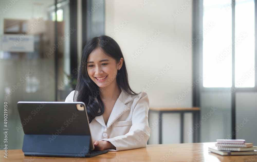 Pleasant young business woman checking financial data on computer tablet. Pleasant young business woman checking financial data on computer tablet.