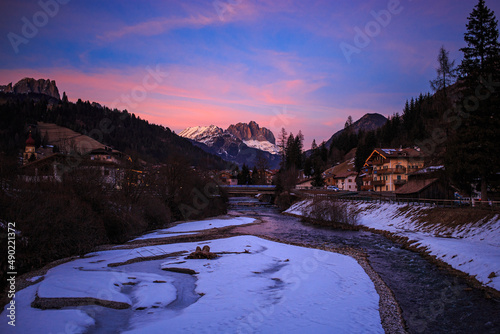 Mesmerizing view of the sunset sky over the frozen river in winter in Parco Lago Soraga photo