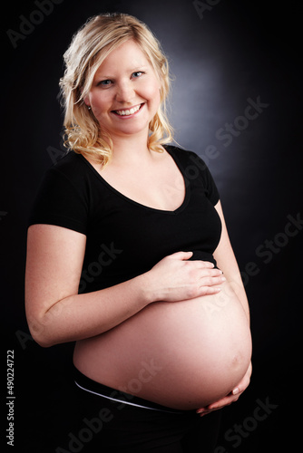 Shes such a proud mother. Portrait of a beautiful smiling woman who is expecting. photo