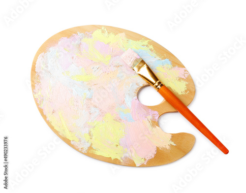 Wooden artist's palette with mixed pastel paints and brush isolated on white, top view