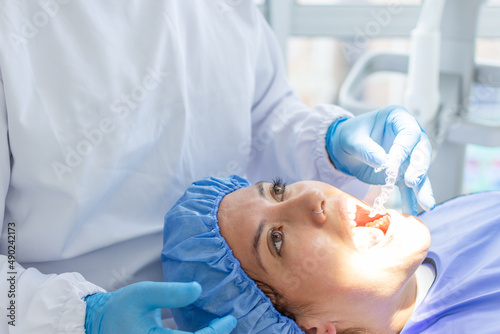 close-up of woman with open mouth in a dental clinic wile a dentist to put a transparent dental brace. Dental clinic concept