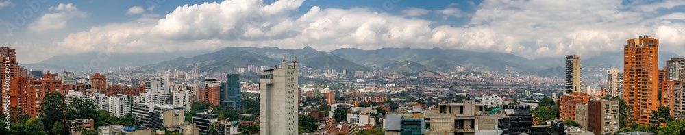 Panorama of skyline Medellin with white cloud covered mountains in the back, Colombia

