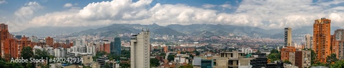 Panorama of skyline Medellin with white cloud covered mountains in the back, Colombia 