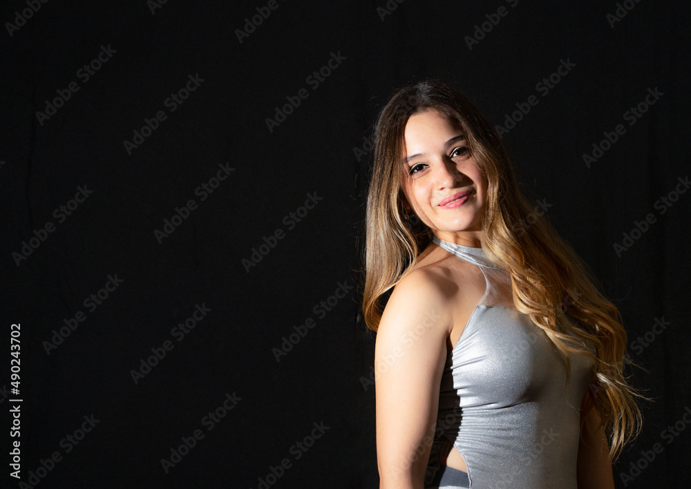 Young latin woman ballet model. with ballet shoes. exercising happy, smiling. with black background and copy space for advertising. low key photo.