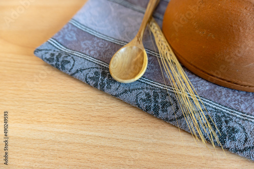 Wooden spoon on a wooden table with a kitchen towel.