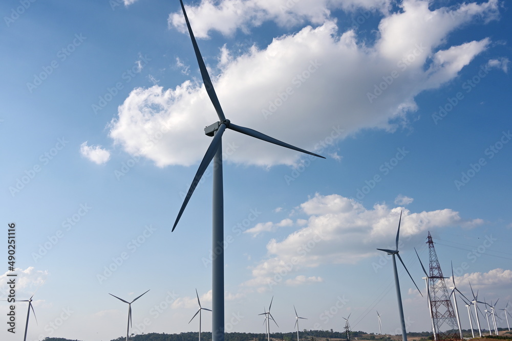 Onshore windmill power plant. The scattered white clouds contrasted with the blue sky and windmills are lined up in a long row. The concept of using circulating wind to generate electricity.
Onshore windmill power plant. The scattered white clouds contrasted with the blue sky and windmills are lined up in a long row. The concept of using circulating wind to generate electricity.
