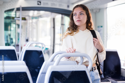 Young attractive lady, public transport passenger, enjoying her travel inside tram