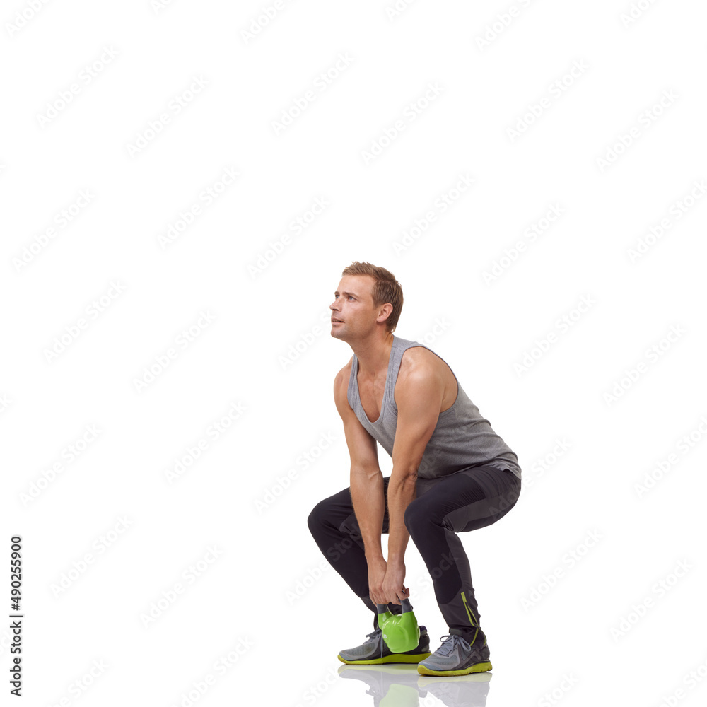 Crouching with his kettlebell. A handsome young man working out with a kettlebell while isolated on a white background. Crouching with his kettlebell. A handsome young man working out with a kettlebell while isolated on a white background.