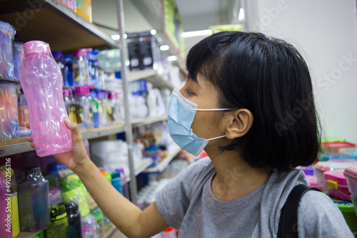 Young asian woman with face mask buying groceries in the supermarket during virus pandemic
