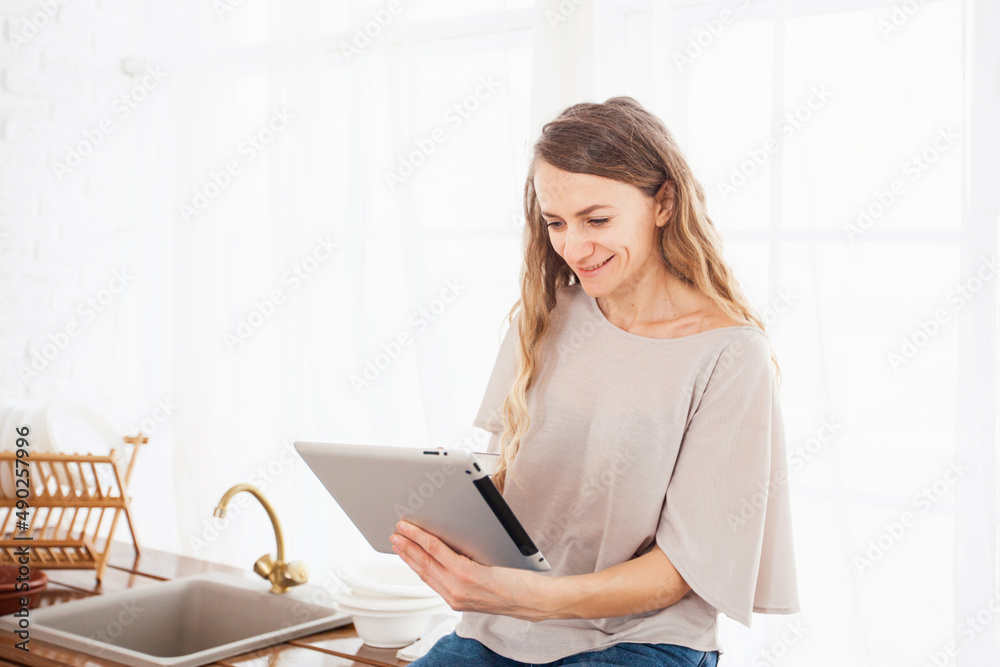 young woman in the kitchen with a tablet young woman in the kitchen with a tablet