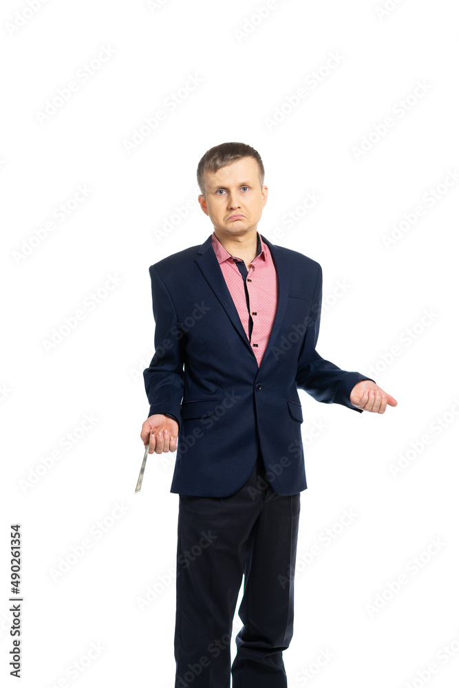 business man in a suit. a young man holds dollars and is sad. a person is not happy with his earnings. isolated business man in a suit. a young man holds dollars and is sad. a person is not happy with his earnings. isolated