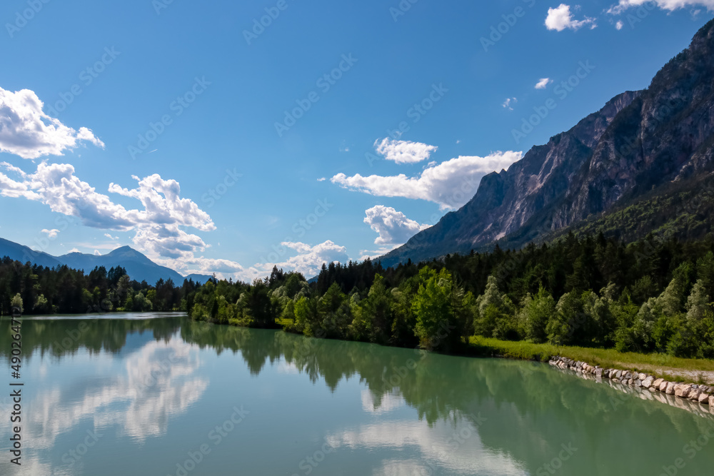 River Gail flowing through the Schuett in the natural park Dobratsch in Villach, Carinthia, Austria. Gailtaler and Villacher Alps. River gets very broad. Reflections in crystal clear water. Mountains