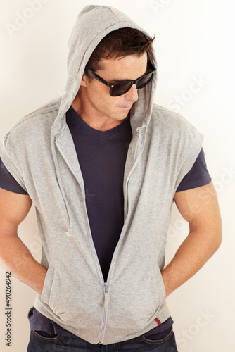 Hes really cool. A young man dressed casually with a hoodie and sunglasses.