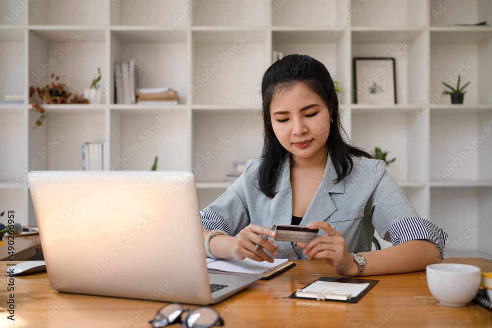 Focused young woman making banking online or payment online with laptop computer. Focused young woman making banking online or payment online with laptop computer.