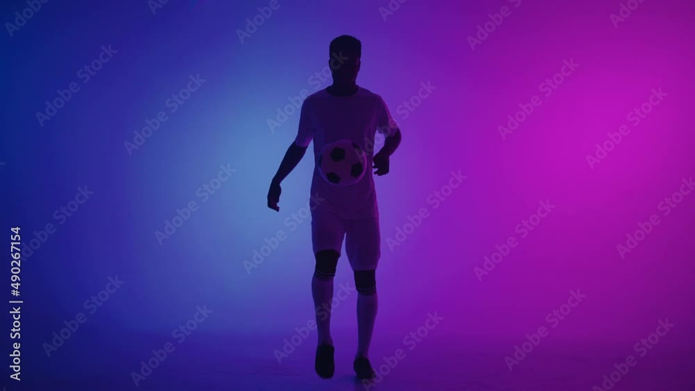 professional football player is doing kick-ups with ball and catching it, portrait of african man professional football player is doing kick-ups with ball and catching it, portrait of african man