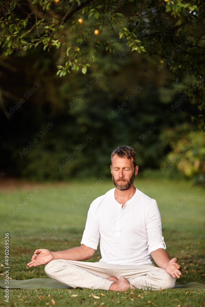 Peaceful moments in nature. Shot of a handsome mature man sitting in the lotus position with his eyes closed. Peaceful moments in nature. Shot of a handsome mature man sitting in the lotus position with his eyes closed.