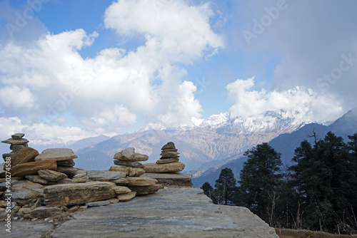 Prayer stone stacks with cloudy blue sky and green mountain view