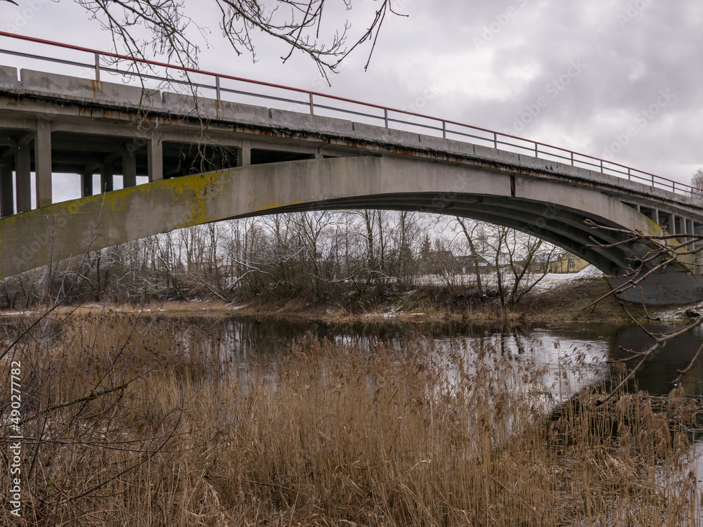 concrete arched bridge over a small and wild river