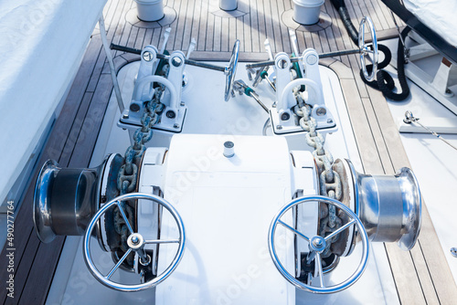 Bow part of the yacht with anchor stops, part of the anchor chain and stainless steel winches. photo