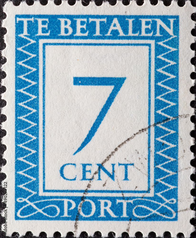 Netherlands - circa 1947: a postage stamp from the Netherlands , showing a number with an ornamental border. In blue.Text: The postage has been paid. Postage due . 7 cent