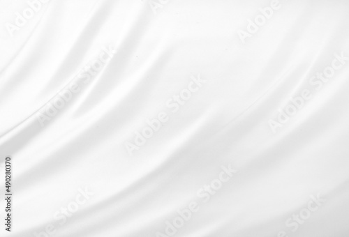 Close up of white silk textured cloth background. Smooth elegant white silk or satin luxury cloth texture can use as wedding background. Luxurious background design. White fabric texture background.