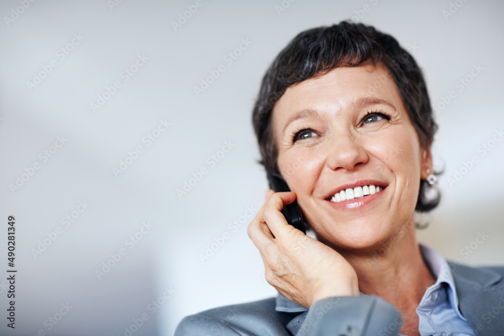 Business woman smiling at work. Low angle view of smiling business woman using cellphone at home. Business woman smiling at work. Low angle view of smiling business woman using cellphone at home.