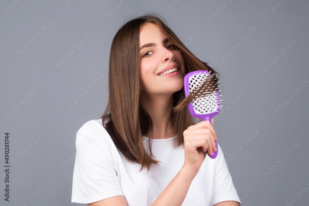 Young beautiful woman combing hair. Hair Care. Beautiful brunette woman hairbrushing hair with hairbrush. Brushing healthy hair with comb. Young beautiful woman combing hair. Hair Care. Beautiful brunette woman hairbrushing hair with hairbrush. Brushing healthy hair with comb.