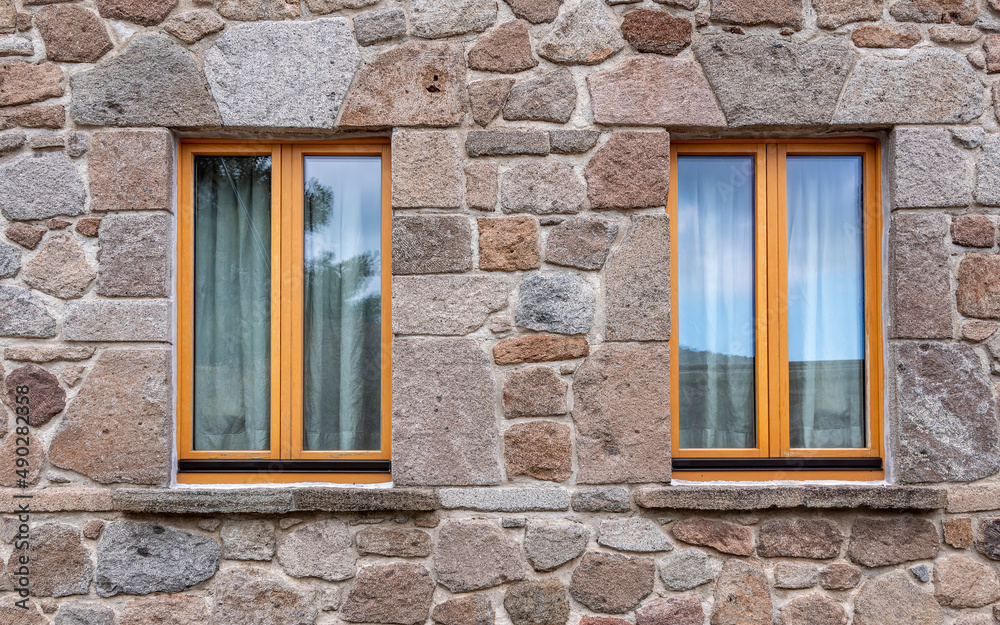 Two windows isolated on rough stonewall, some space for your text or logo Two windows isolated on rough stonewall, some space for your text or logo