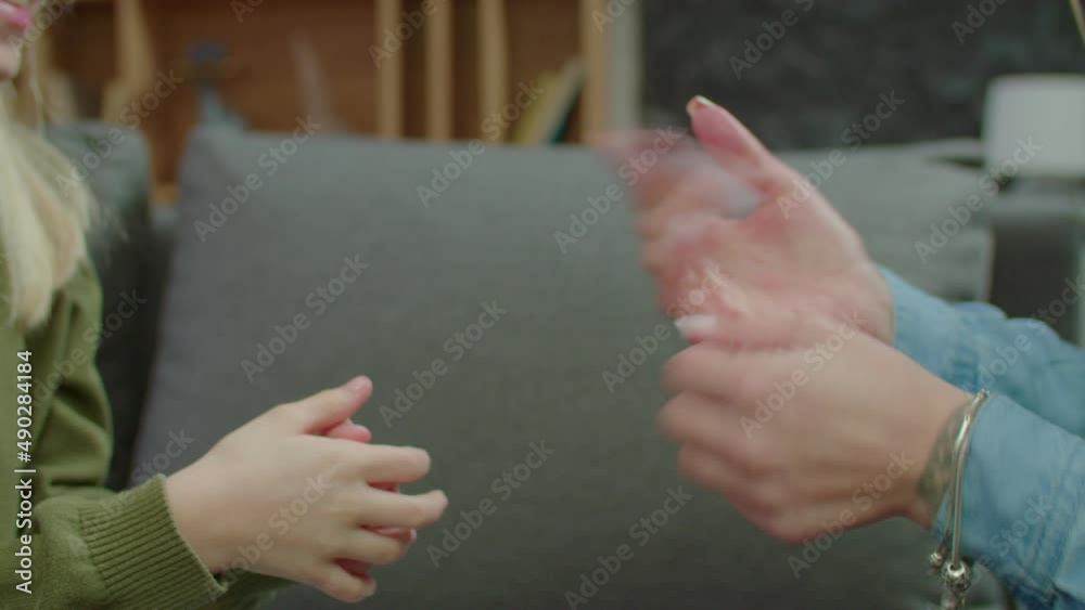 Close-up of hearing impaired mother and school age girl with communication disorder friendly chatting and sharing using sign language, showing strong relationship and understanding.