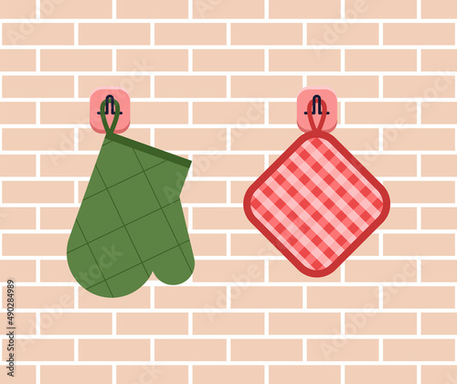Kitchen utensils on the background of a brick wall. Potholder and backing on hooks in flat design. Vector stock illustration
