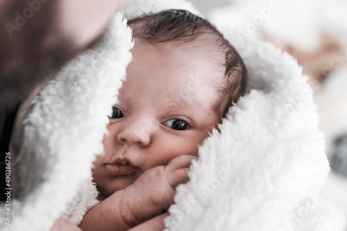 Portrait of newborn wrapped in warm-looking blanket