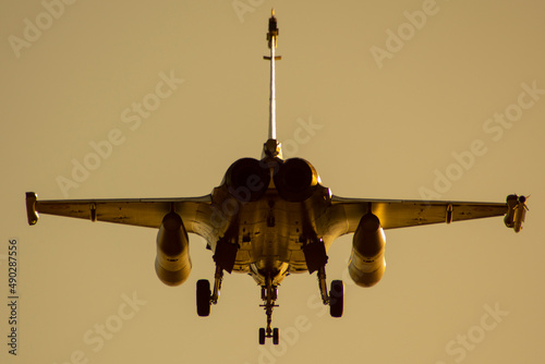 Avión de combate Rafale bimotor aterrizando al atardecer photo