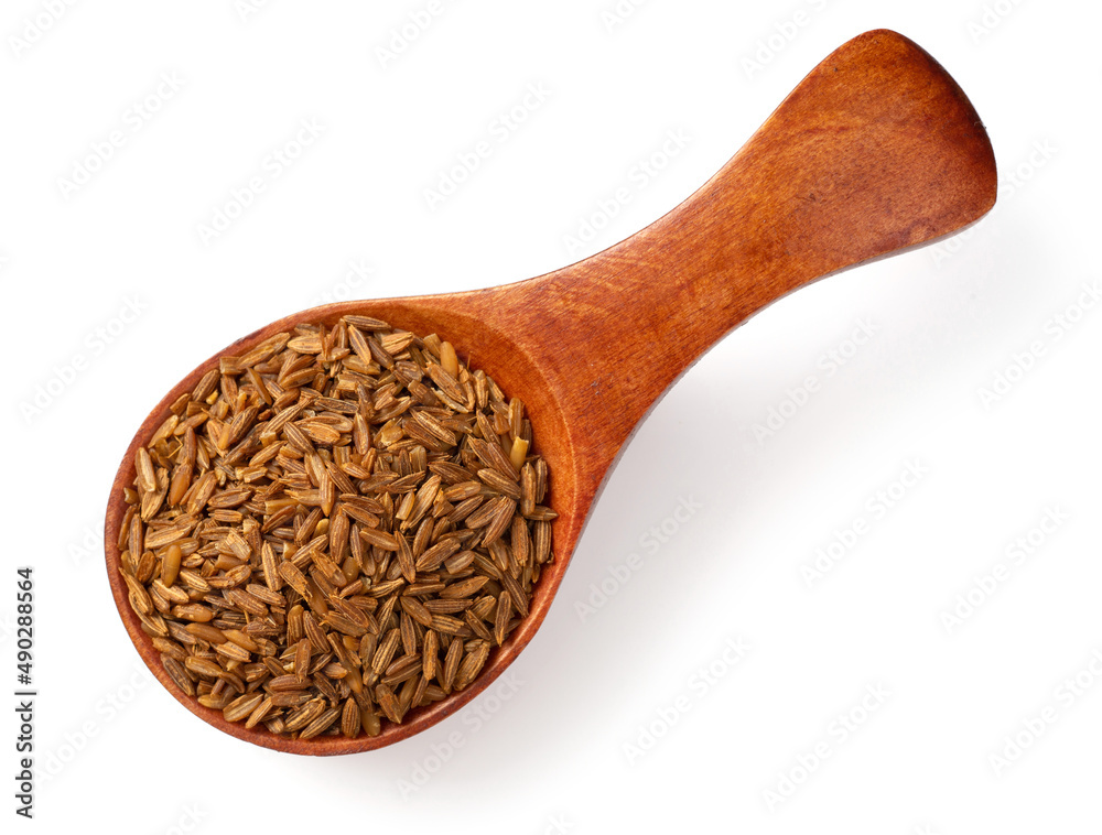 Roasted cumin seeds in the wooden spoon, isolated on the white background. Roasted cumin seeds in the wooden spoon, isolated on the white background.