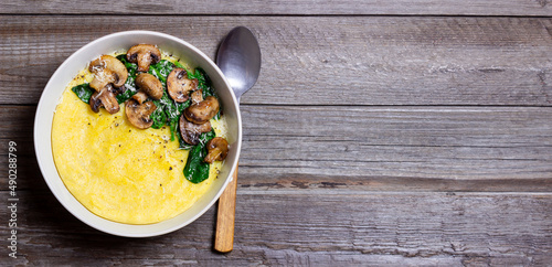 Polenta with mushrooms, spinach and cheese. Healthy eating. Vegetarian food. Italian cuisine.