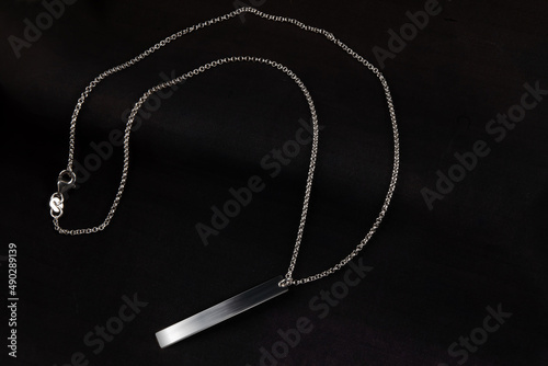 Silver jewelry chain bracelet necklace isolated on black engraving plate photo