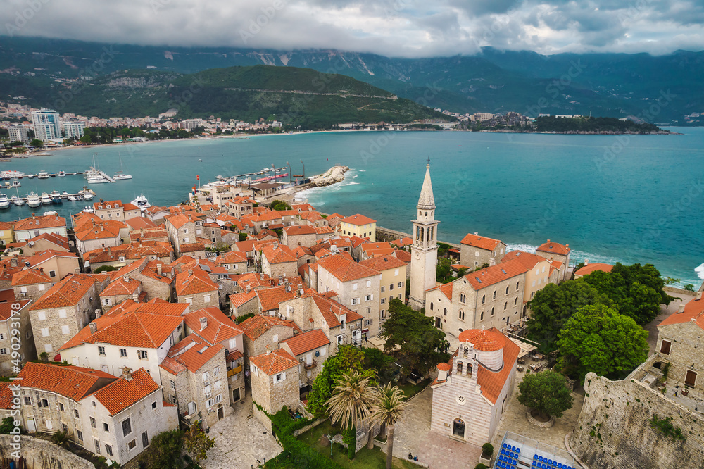 Aerial view of Budva old town with mighty sea waves, famous touristic place in Montenegro