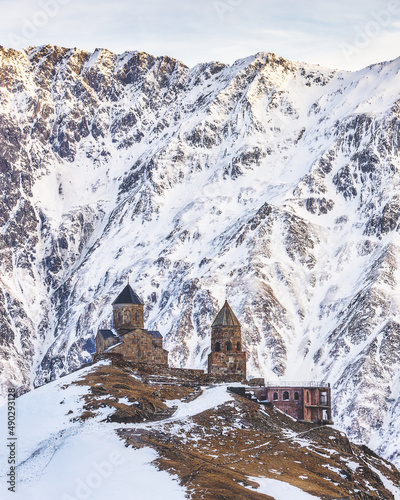 Famous view of Gergety Trinity church and mountains of Caucasus in Kazbegi, Georgia photo