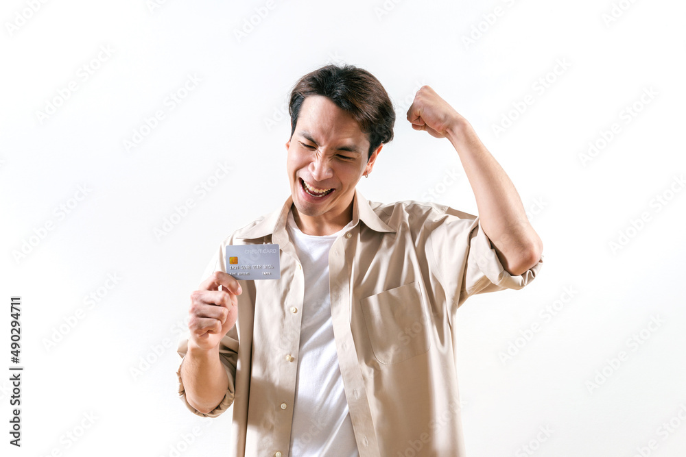 Smart young man is excited happy with a new credit card and ready to pay a bill. Plastic Money online technology or e-money and online shopping concept ideas for new generation. Over white background Smart young man is excited happy with a new credit card and ready to pay a bill. Plastic Money online technology or e-money and online shopping concept ideas for new generation. Over white background