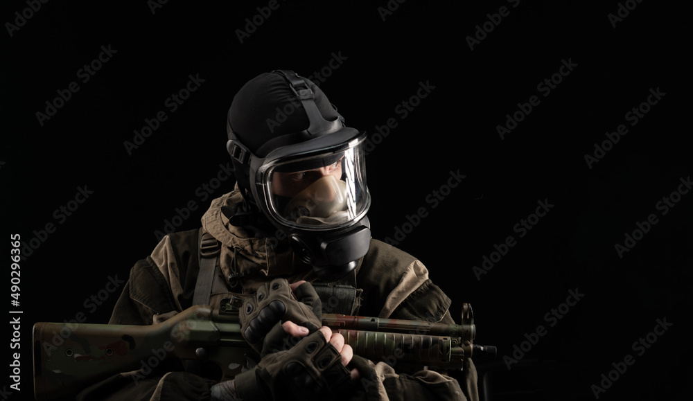 a man in a military uniform and a gas mask holds a weapon with an angry expression of emotion