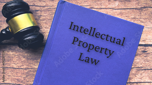 Intellectual property law book and gavel on wooden table.