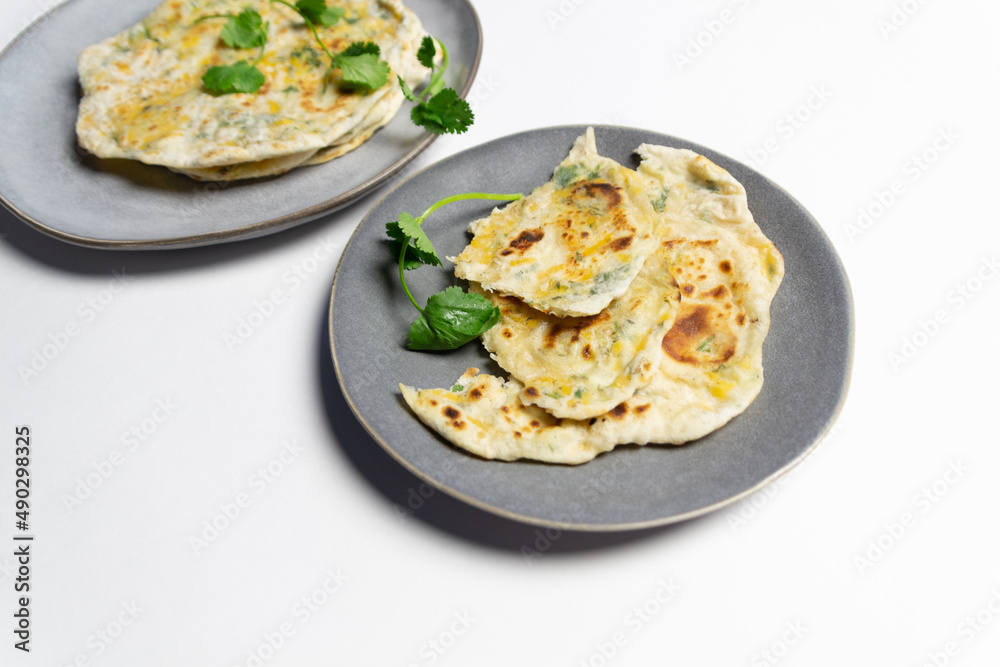 Filled with cheese and cilantro fpancakes on plate on white background
