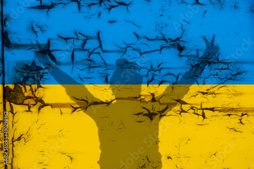 Girl making a victory sign on the flag of Ukraine