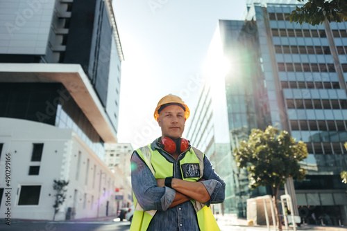 Self-confident construction worker standing with his arms crossed photo