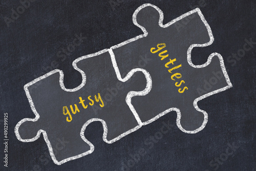 Принти на полотні Chalk drawing of two puzzles with words gutsy and gutless