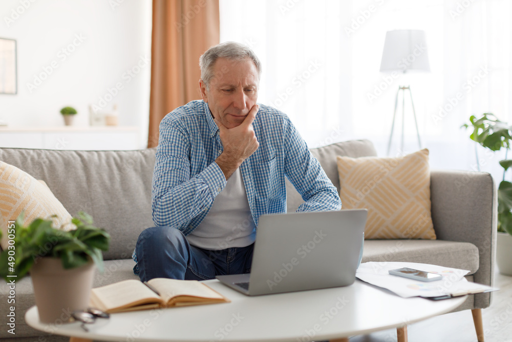 Portrait of pensive mature using laptop at home Portrait of pensive mature using laptop at home