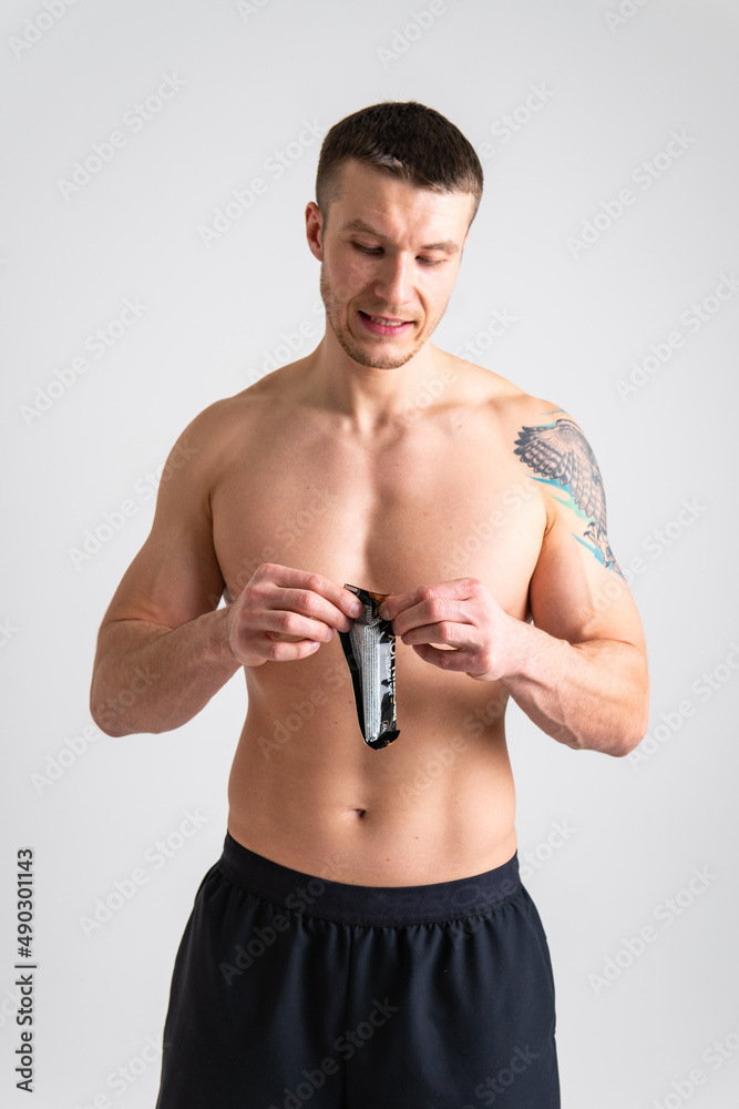 Fototapeta premium Man eats protein bar on white background isolated protein healthy, eating man sport white person, isolated Sugar adult, cereal female