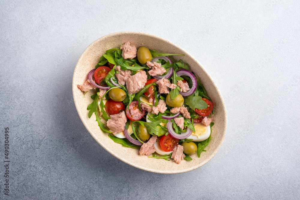 Healthy tuna salad with fresh arugula, cherry tomatoes, quail egg and olives Healthy tuna salad with fresh arugula, cherry tomatoes, quail egg and olives
