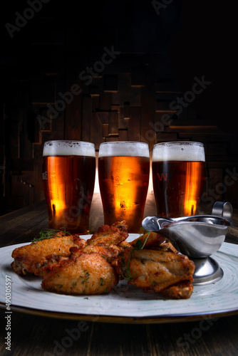 fried chicken wings served with beer on a dark background